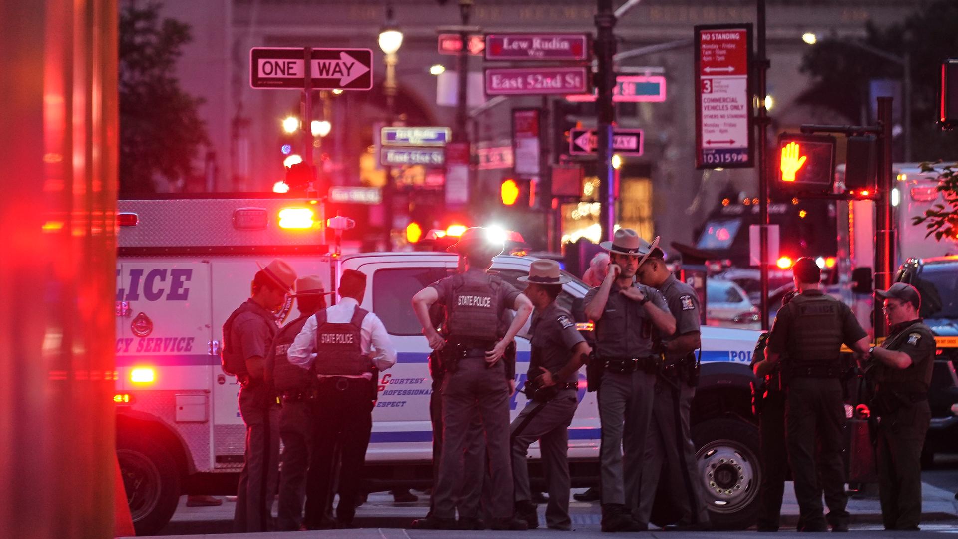 Auf einer Straße sind zahlreiche Einsatzfahrzeuge der New Yorker Polizei zu sehen, die sich vor einem Bürogebäude versammeln.