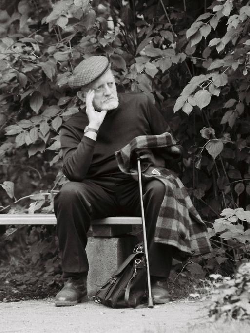 Der Schriftsteller Erwin Strittmatter, fotografiert vor einer Lesung in Weimar im September 1992. Er sitzt, gestützt auf einen Gehstock, Gedanken verloren auf einer Parkbank.