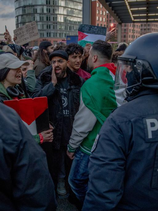 Behelmte Polizisten stehen am Potsdamer Platz in Berlin einer großen Menge pro-palästinensischer Demonstranten gegenüber.