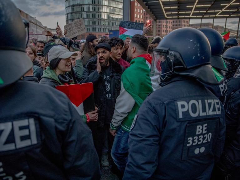 Behelmte Polizisten stehen am Potsdamer Platz in Berlin einer großen Menge pro-palästinensischer Demonstranten gegenüber.