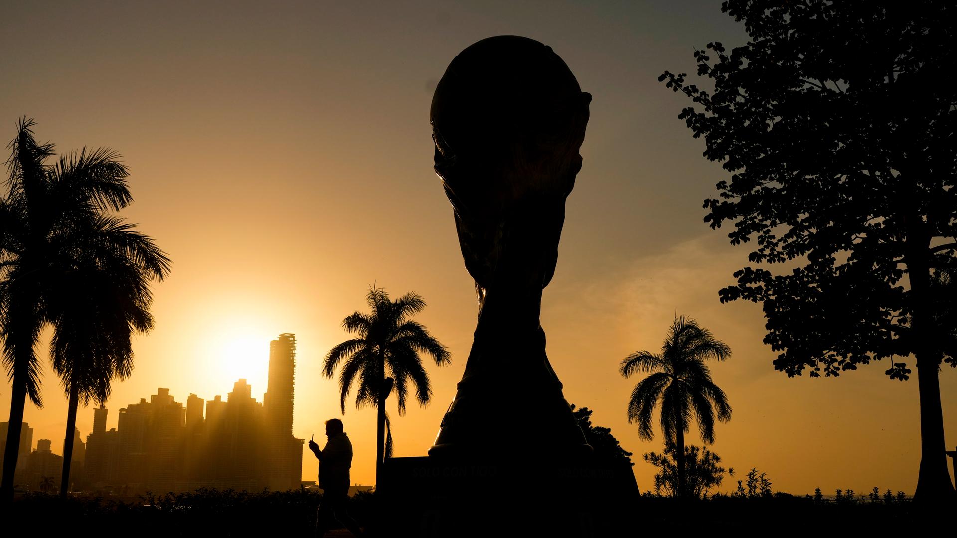 Eine Nachbildung des Fußball-WM-Pokals ist bei Sonnenuntergang im Gegenlicht zu sehen. Eine Nachbildung des Fußball-WM-Pokals ist bei Sonnenuntergang im Gegenlicht zu sehen.