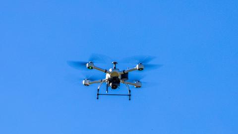 Eine Drohne schwebt im blauen Himmel 