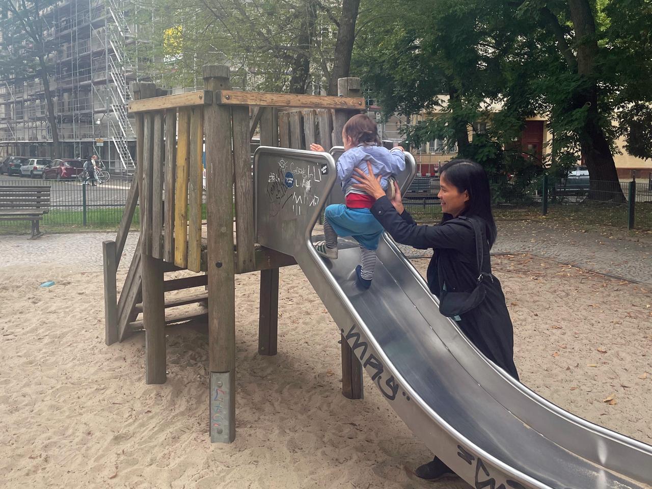 Basilisa Dengen spielt mit ihrem Kind auf einem Spielplatz.