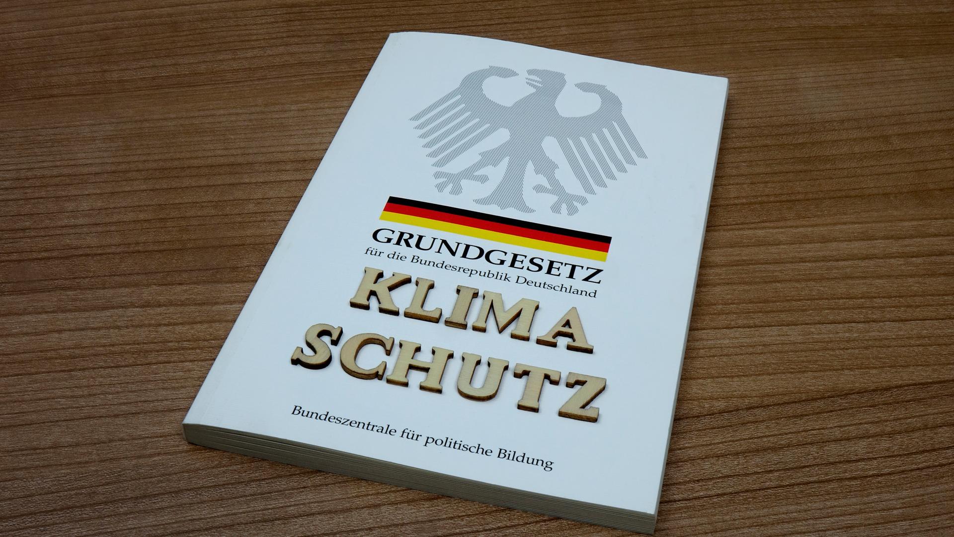 Das Wort "Klimaschutz" steht in einer Bild-Grafik auf einer Ausgabe des Grundgesetzes.