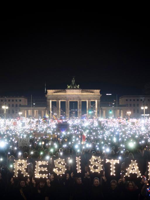 Lichtermeer bei einer Demonstration vor dem Brandenburger Tor in Berlin. Einige Lichter formen die Wörter "Hope and Restistance".