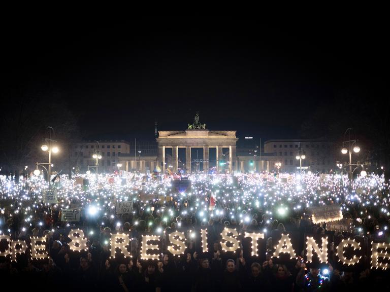 Lichtermeer bei einer Demonstration vor dem Brandenburger Tor in Berlin. Einige Lichter formen die Wörter "Hope and Restistance".
