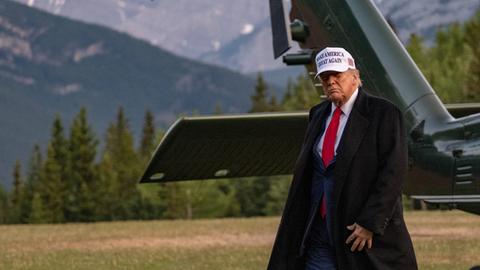 Donald Trump vor einem Militär-Hubschrauber. Er läuft.