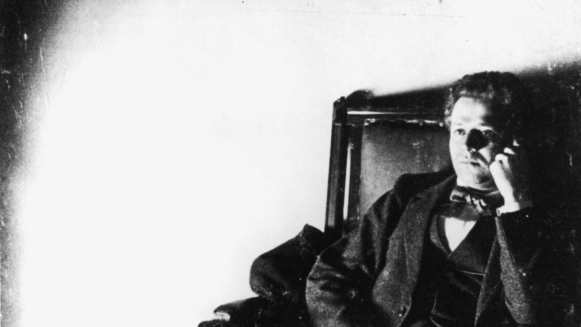 Kurt Tucholsky sitzt gedankenversunken auf einem Sofa.