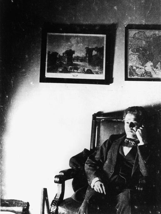 Kurt Tucholsky sitzt gedankenversunken auf einem Sofa.