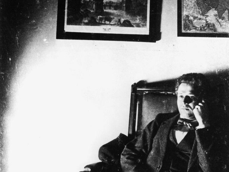 Kurt Tucholsky sitzt gedankenversunken auf einem Sofa.