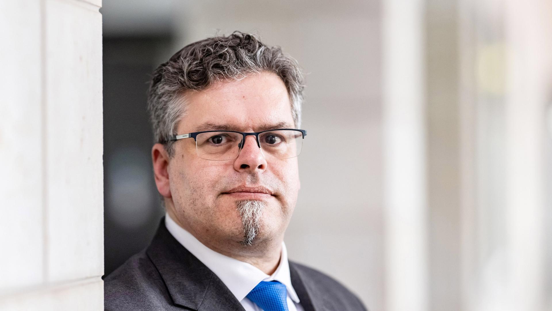 Jens Rommel, neuer Generalbundesanwalt, steht angelehnt an eine helle Mauer und schaut in die Kamera Jens Rommel, neuer Generalbundesanwalt, steht angelehnt an eine helle Mauer und schaut in die Kamera