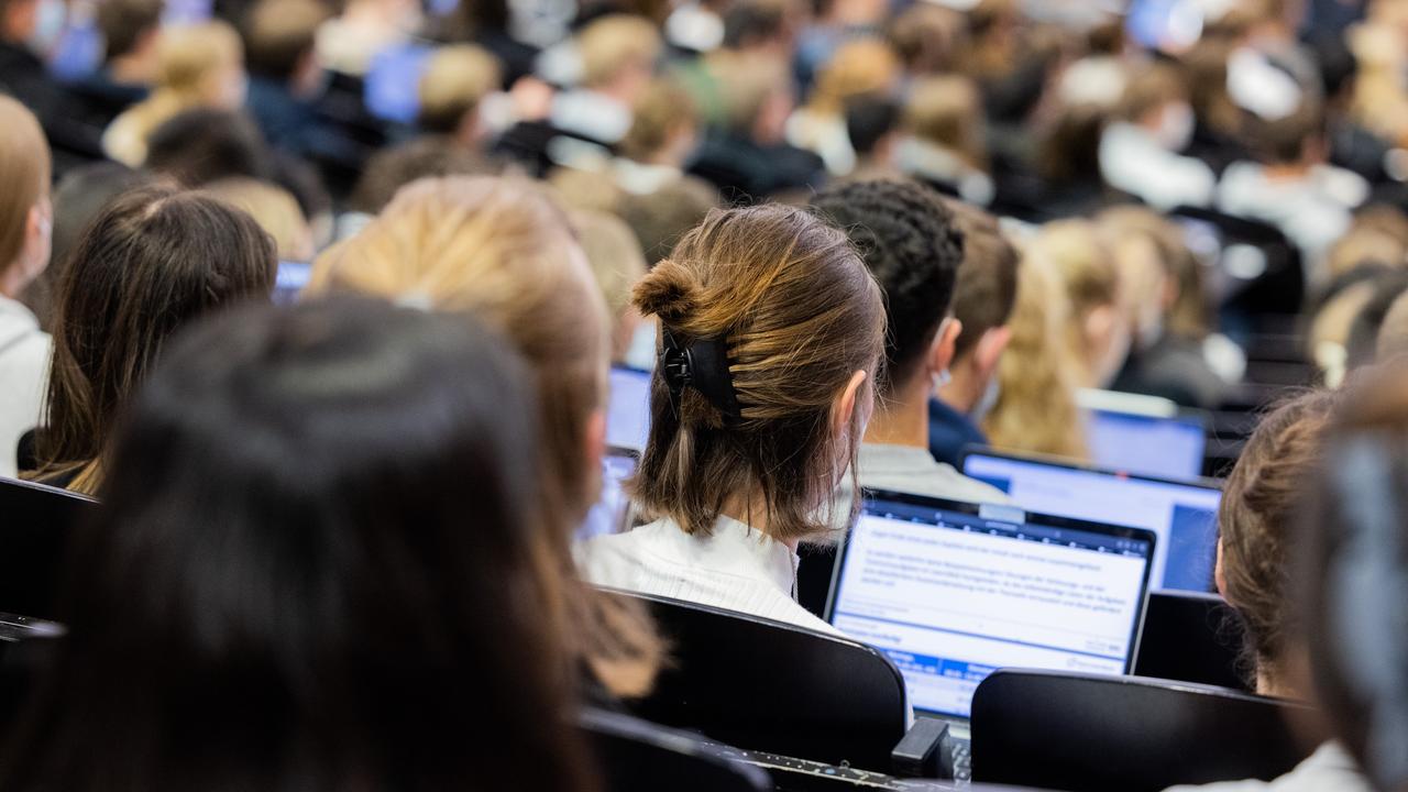 Studentinnen und Studenten sitzen während einer Vorlesung in einem Hörsaal in Münster.