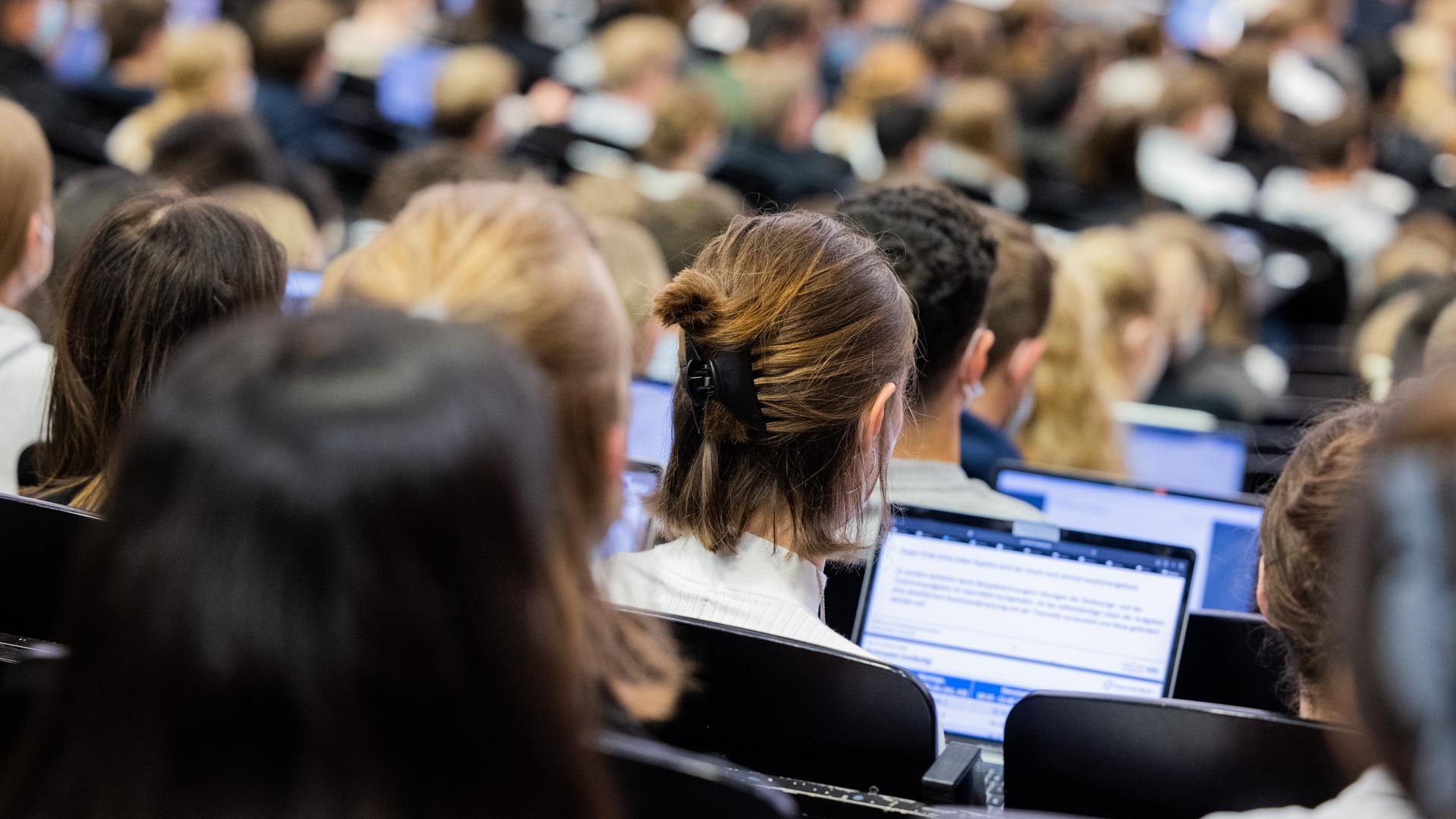 Studentinnen und Studenten sitzen während einer Vorlesung in einem Hörsaal in Münster.