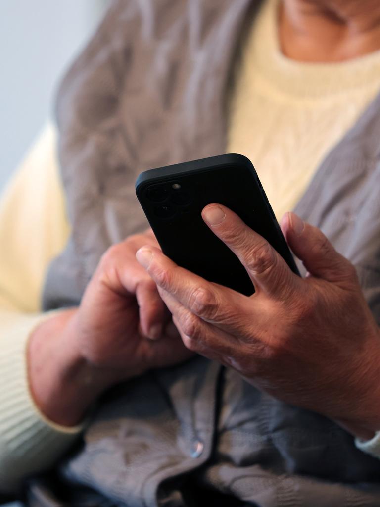 Eine Seniorin schreibt eine Nachricht in ihr Handy. 