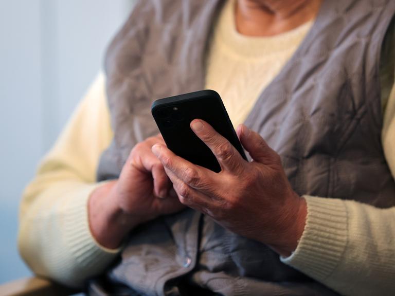 Eine Seniorin schreibt eine Nachricht in ihr Handy. Eine Seniorin schreibt eine Nachricht in ihr Handy.