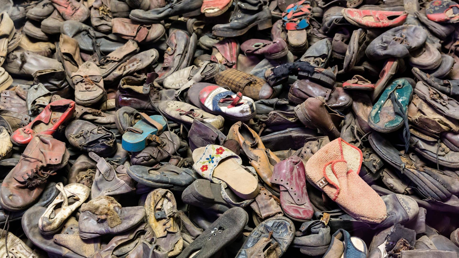 Schuhe von Opfern des Holocaust im ehemaligen Konzentrationslager Auschwitz. Sie liegen durcheinander auf einem Haufen.