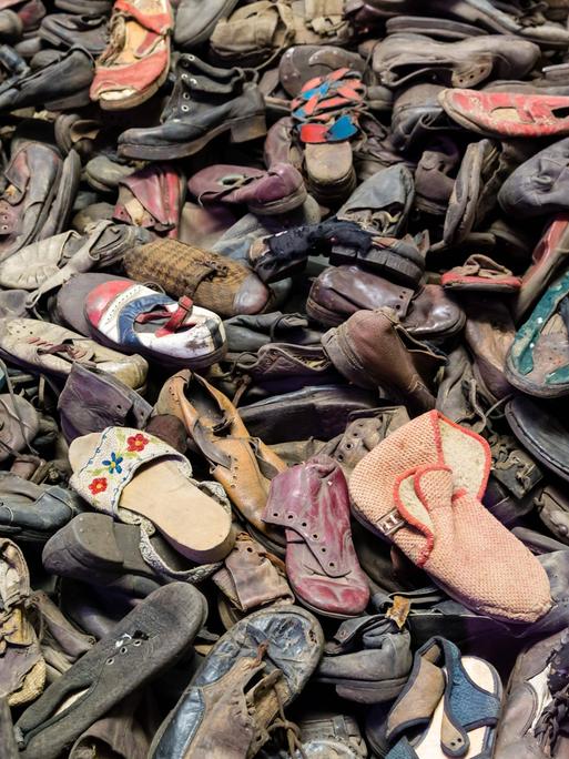Schuhe von Opfern des Holocaust im ehemaligen Konzentrationslager Auschwitz. Sie liegen durcheinander auf einem Haufen.