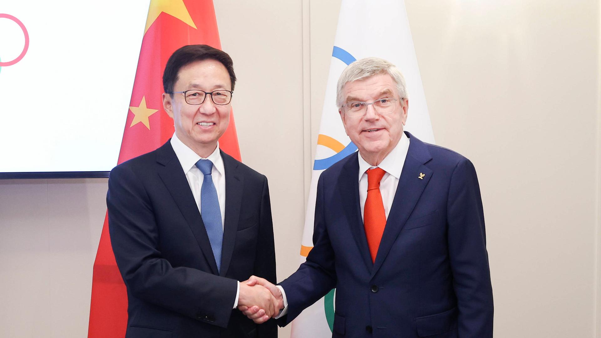 IOC-Präsident Thomas Bach (r.) schüttelt im Rahmen der Olympischen Spiele 2024 Chinas Vizepräsident Han Zheng die Hand.