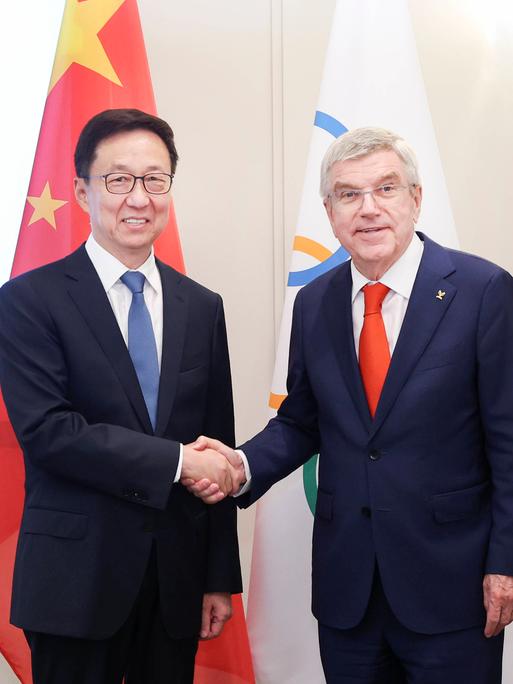 IOC-Präsident Thomas Bach (r.) schüttelt im Rahmen der Olympischen Spiele 2024 Chinas Vizepräsident Han Zheng die Hand.