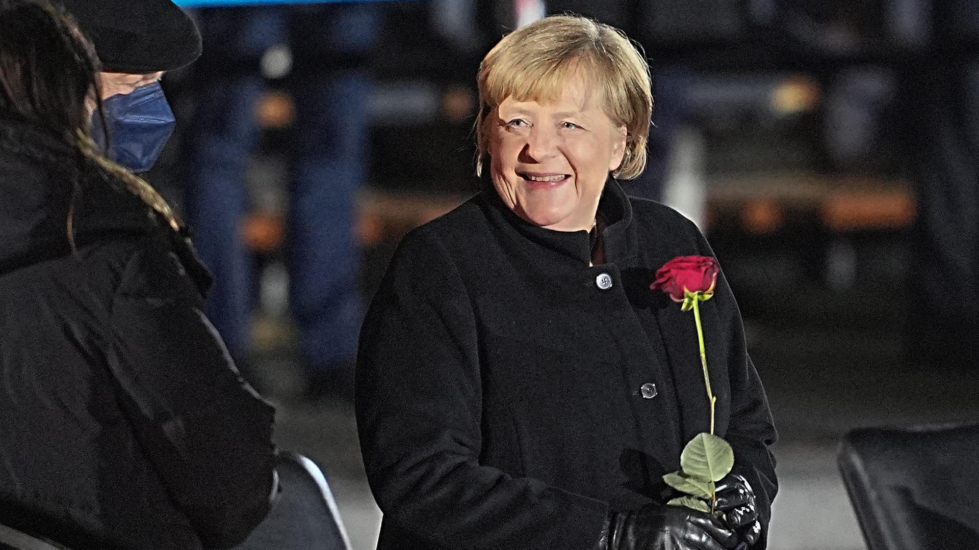 Bundeskanzlerin Angela Merkel (CDU) lacht nach ihrer Verabschiedung durch die Bundeswehr mit einer Rosen in der Hand neben ihrem Mann, Joachim Sauer. Mit einem Großen Zapfenstreich wird Kanzlerin Merkel gegen Ende ihrer Regierungszeit nach 16 Jahren im Bendlerblock verabschiedet