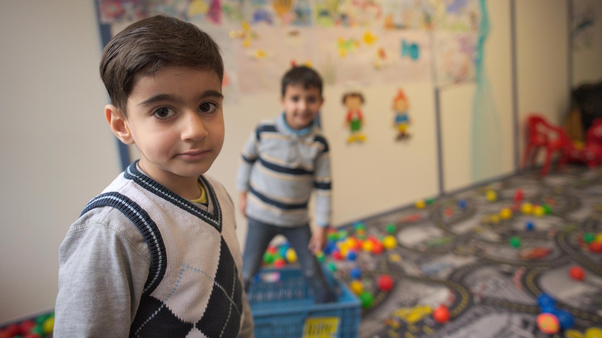 Zwei syrische Kinder spielen in der Kinderbetreuung in einer Flüchtlingsunterkunft.
