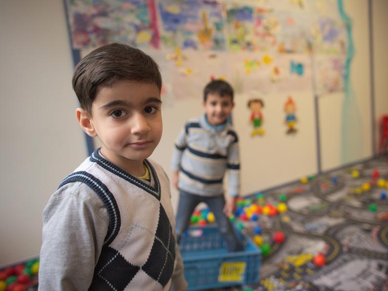 Zwei syrische Kinder spielen in der Kinderbetreuung in einer Flüchtlingsunterkunft.