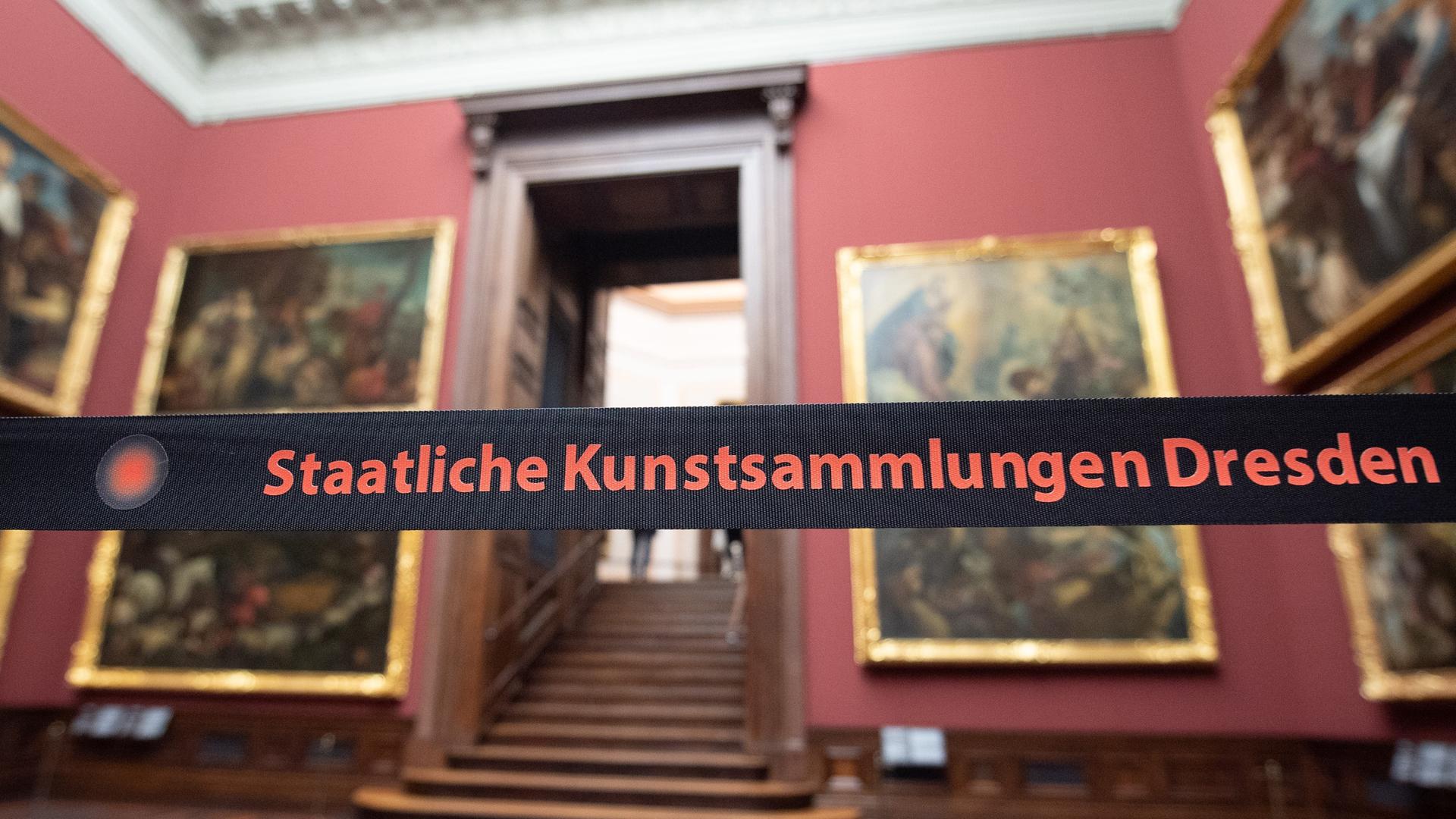 Ein Absperrband mit der Aufschrift "Staatliche Kunstsammlungen Dresden" hängt in der Gemäldegalerie Alte Meister vor den Gemälden. 