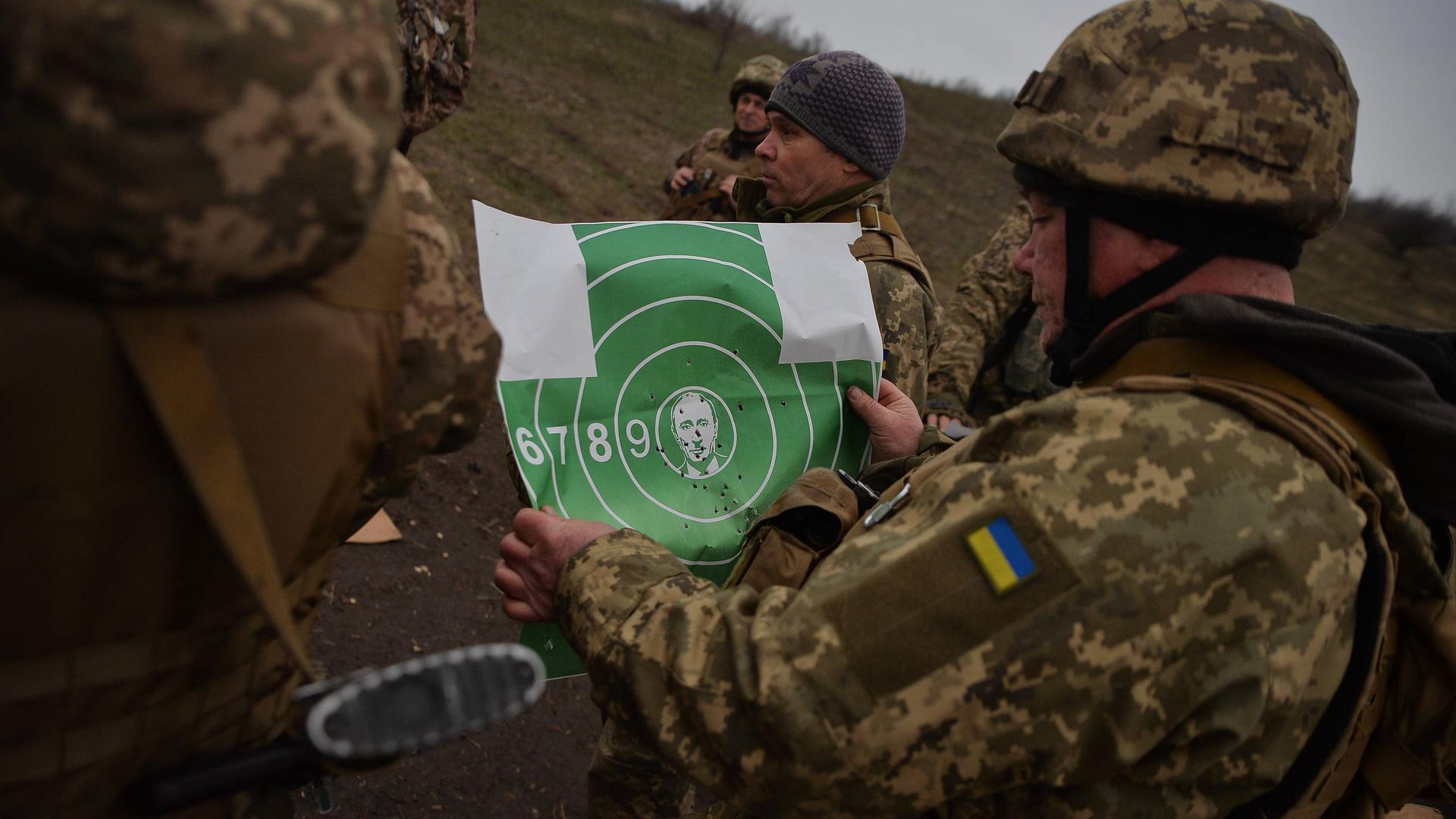 Ukrainische Soldaten in Donezk mit einer Zielscheibe, auf der Putins Bild in der Mitte zu sehen ist