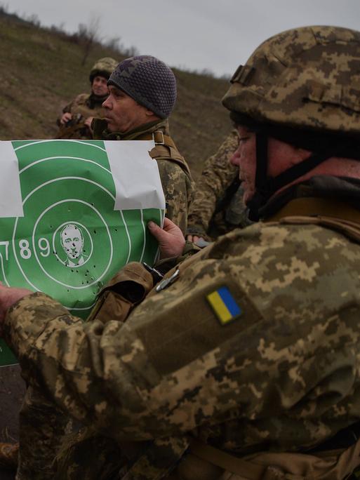 Ukrainische Soldaten in Donezk mit einer Zielscheibe, auf der Putins Bild in der Mitte zu sehen ist