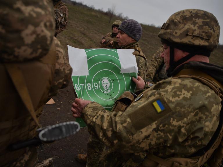 Ukrainische Soldaten in Donezk mit einer Zielscheibe, auf der Putins Bild in der Mitte zu sehen ist