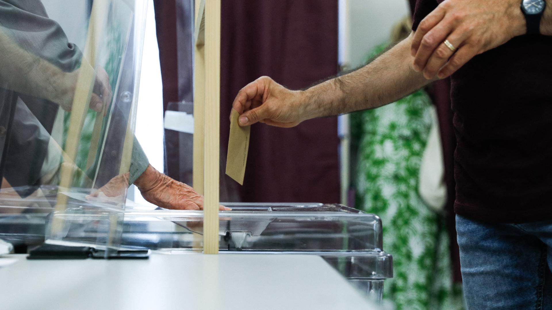 Wahlzettel und -urne beim ersten Wahlgang der Parlamentswahl 2022 in Frankreich