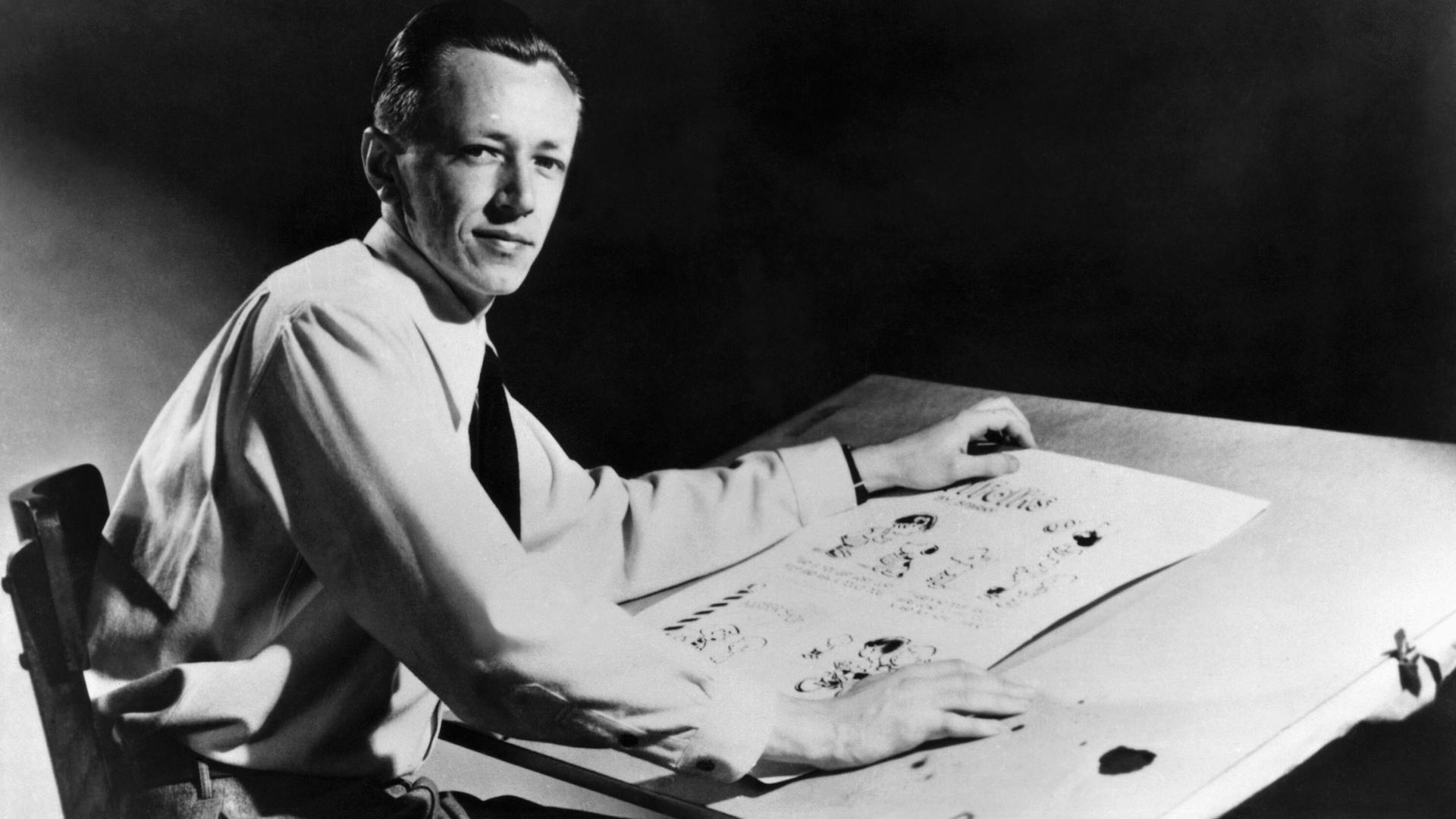 Charles M. Schulz (1922–2000), US-amerikanischer Cartoonist und Schöpfer des Comics „Peanuts“ am Zeichenbrett in einer schwarz-weiß Aufnahme von 1952.