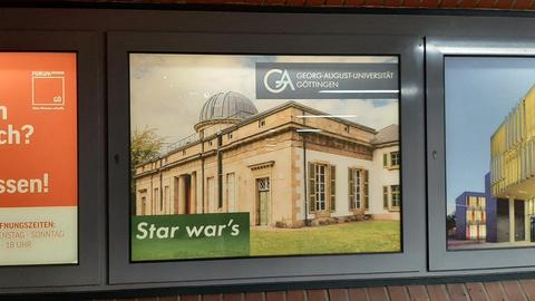 In einem Fenster ist eine Werbung mit dem Bild der alten Göttinger Sternwarte und dem Schriftzug "Star war's" zu sehen.