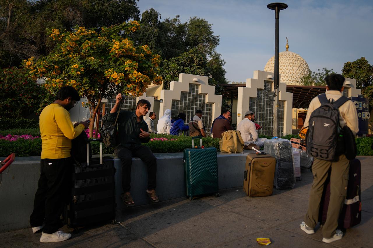 Passagiere warten außerhalb des gesperrten Flughafens in Dubai.