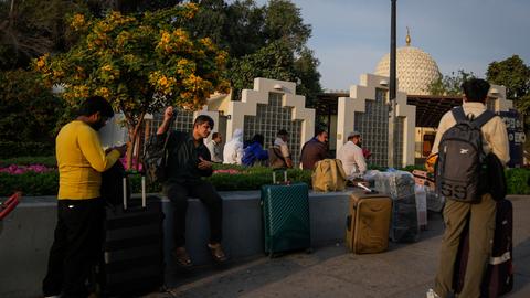 Passagiere warten außerhalb des gesperrten Flughafens in Dubai.