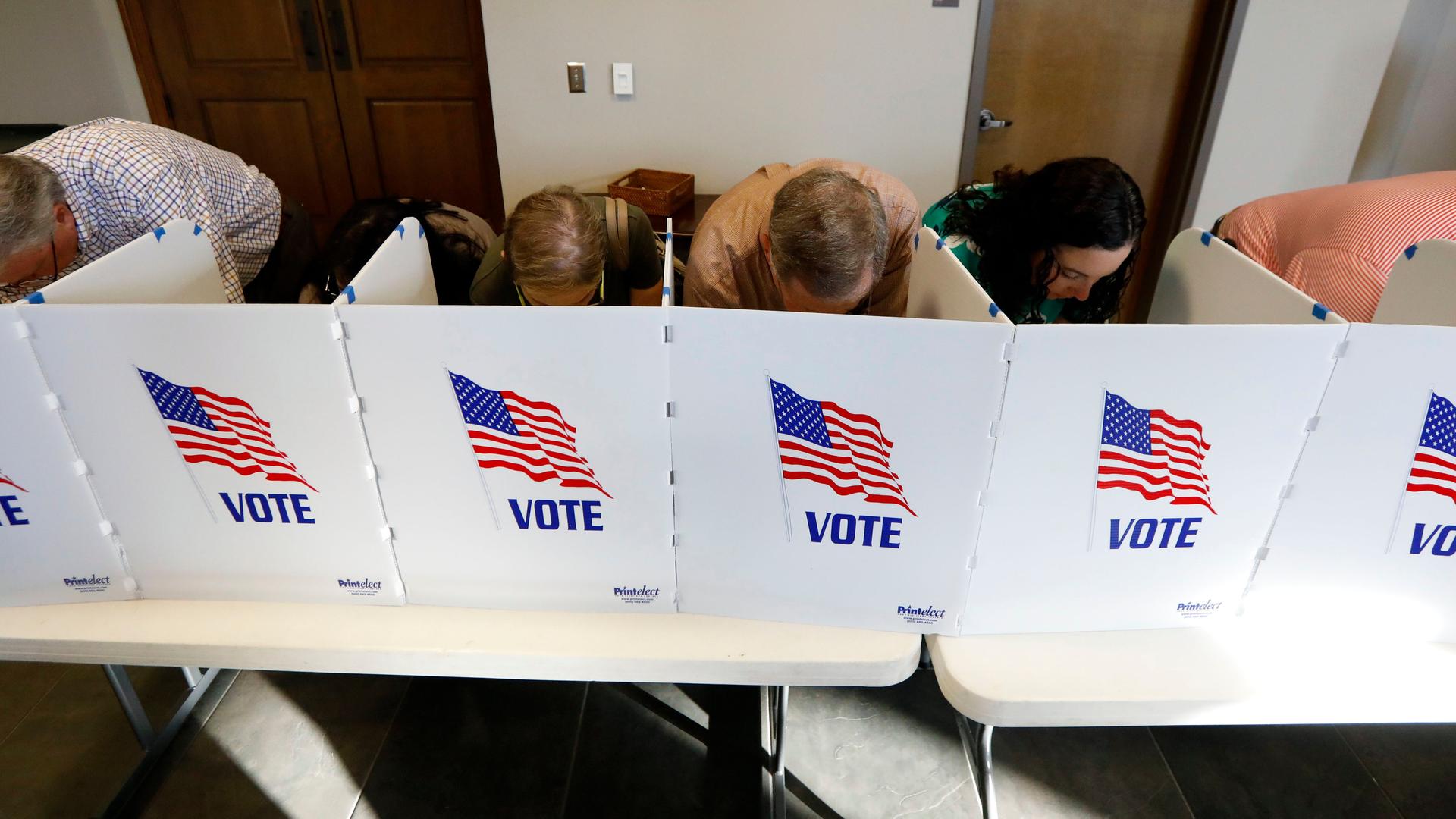 Wahlberechtigte in den USA geben in Wahlkabinen ihre Stimme ab. Wahlberechtigte in den USA geben in Wahlkabinen ihre Stimme ab.