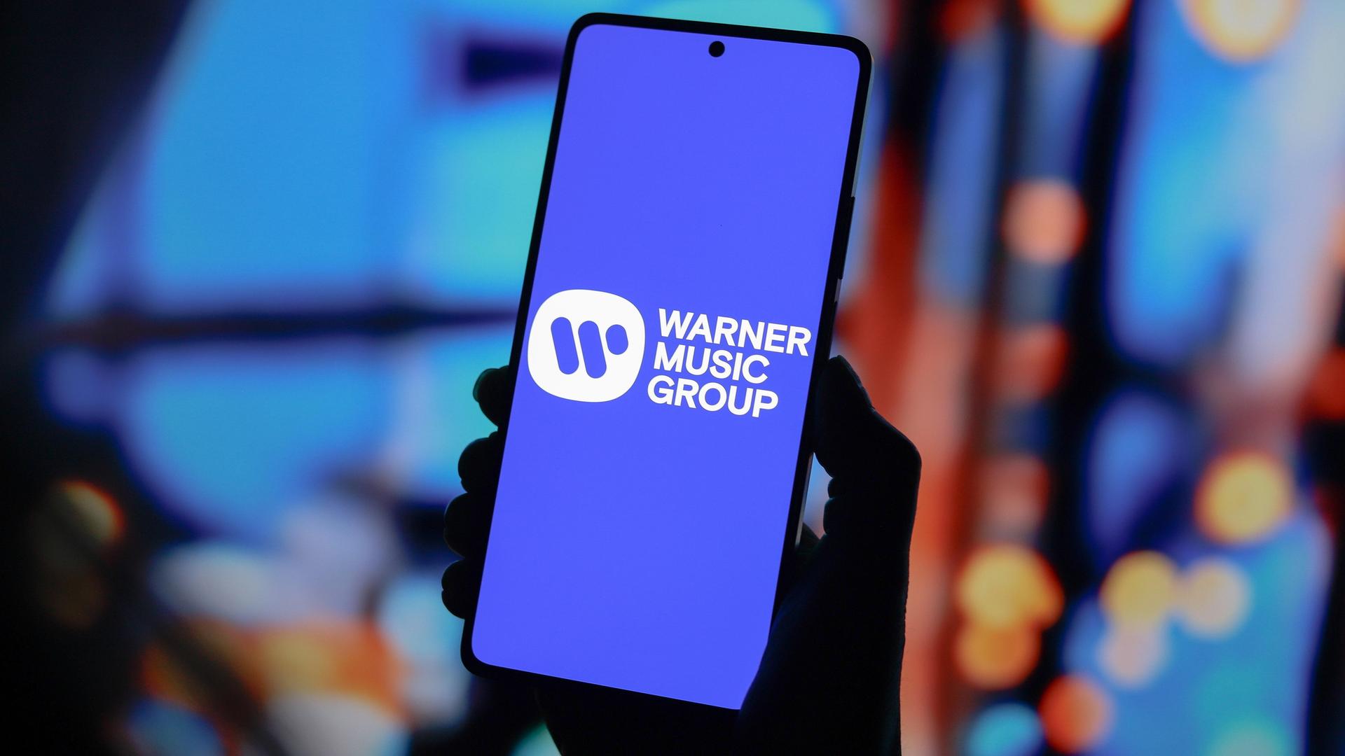 Das Logo des Musikkonzerns Warner Music Group auf dem Bildschirm eines Smartphones.