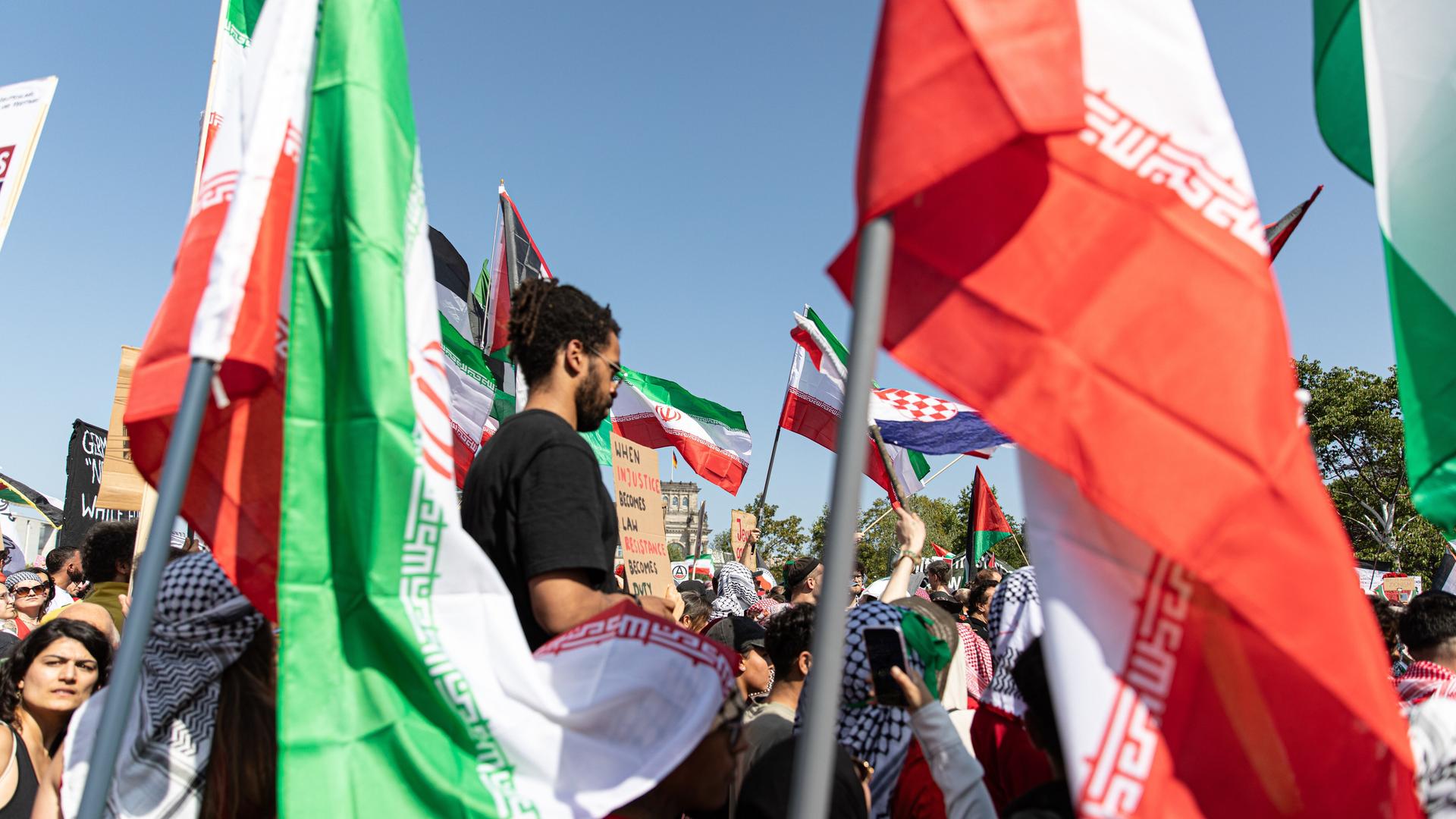 Die Demonstration in Berlin gegen den Krieg im Gazastreifen. Man sieht viele palästinensische Fahnen, Demonstranten und in der Mitte einen Mann. Der Mann steht höher als die anderen Demonstranten. Die Demonstration in Berlin gegen den Krieg im Gazastreifen. Man sieht viele palästinensische Fahnen, Demonstranten und in der Mitte einen Mann. Der Mann steht höher als die anderen Demonstranten.
