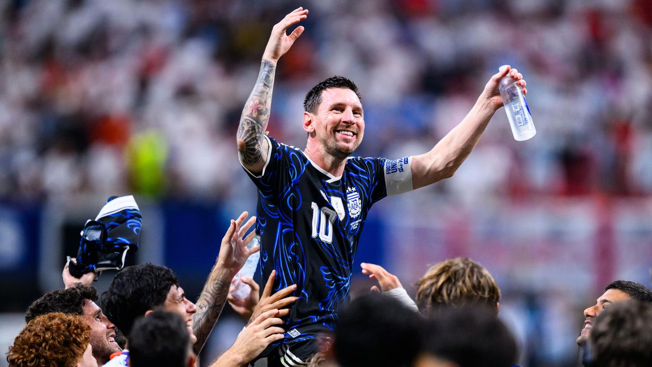 Der Fußball-Spieler von Argentinien Lionel Messi freut sich. Er hat beide Arme noch oben gestreckt. Seine Mit-Spieler heben Lionel Messi hoch.