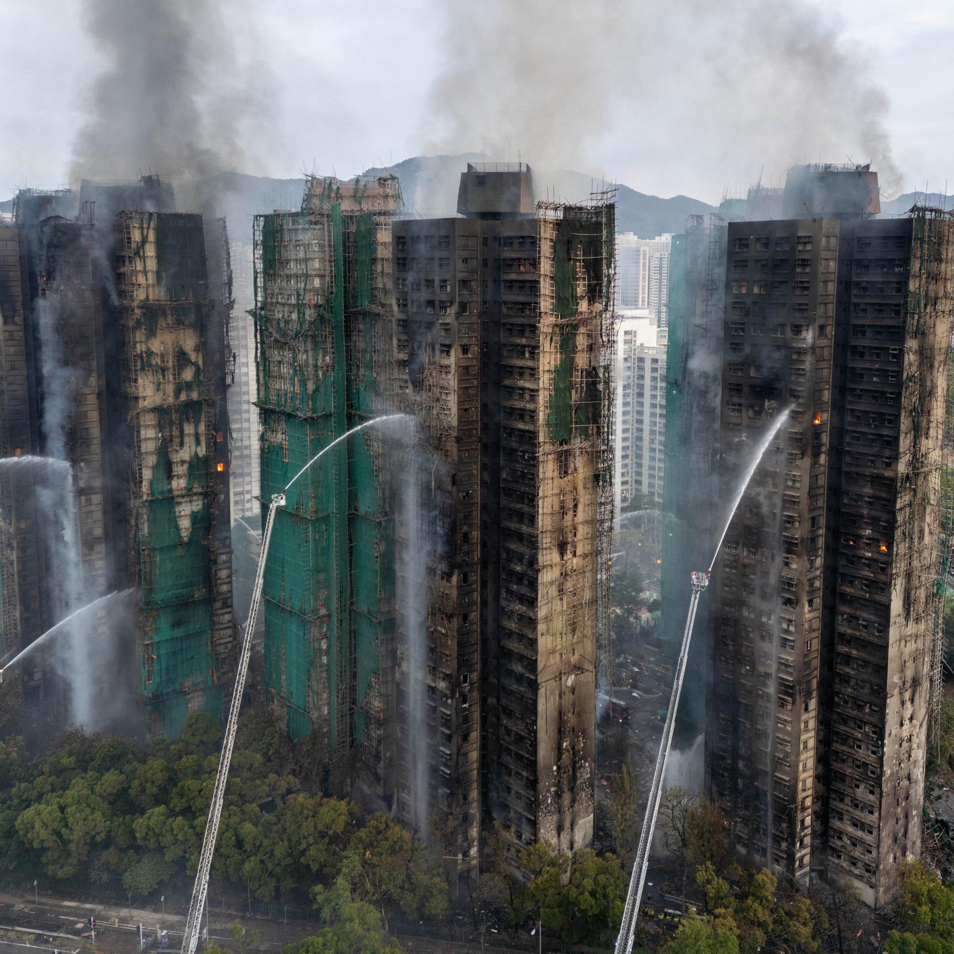Hongkong: Rauch steigt auf, während Feuerwehrleute die letzten Flammen in den Gebäuden im Wang Fuk Court, einer Wohnsiedlung im Stadtteil Tai Po in den New Territories von Hongkong, ausbrach löschen. 