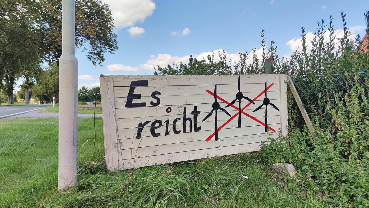 Schilder an einer Straße in Mecklenburg-Vorpommern mit durchgestrichenen Piktogrammen von Windrädern und der Aufschrift "Es reicht".