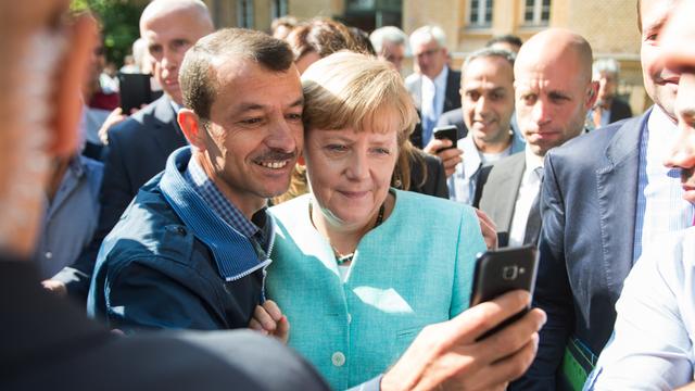 Bundeskanzlerin Angela Merkel (CDU) lässt sich nach dem Besuch einer Erstaufnahmeeinrichtung für Asylbewerber der Arbeiterwohlfahrt (AWO) in Berlin-Spandau für ein Selfie zusammen mit einem Flüchtling fotografieren.
