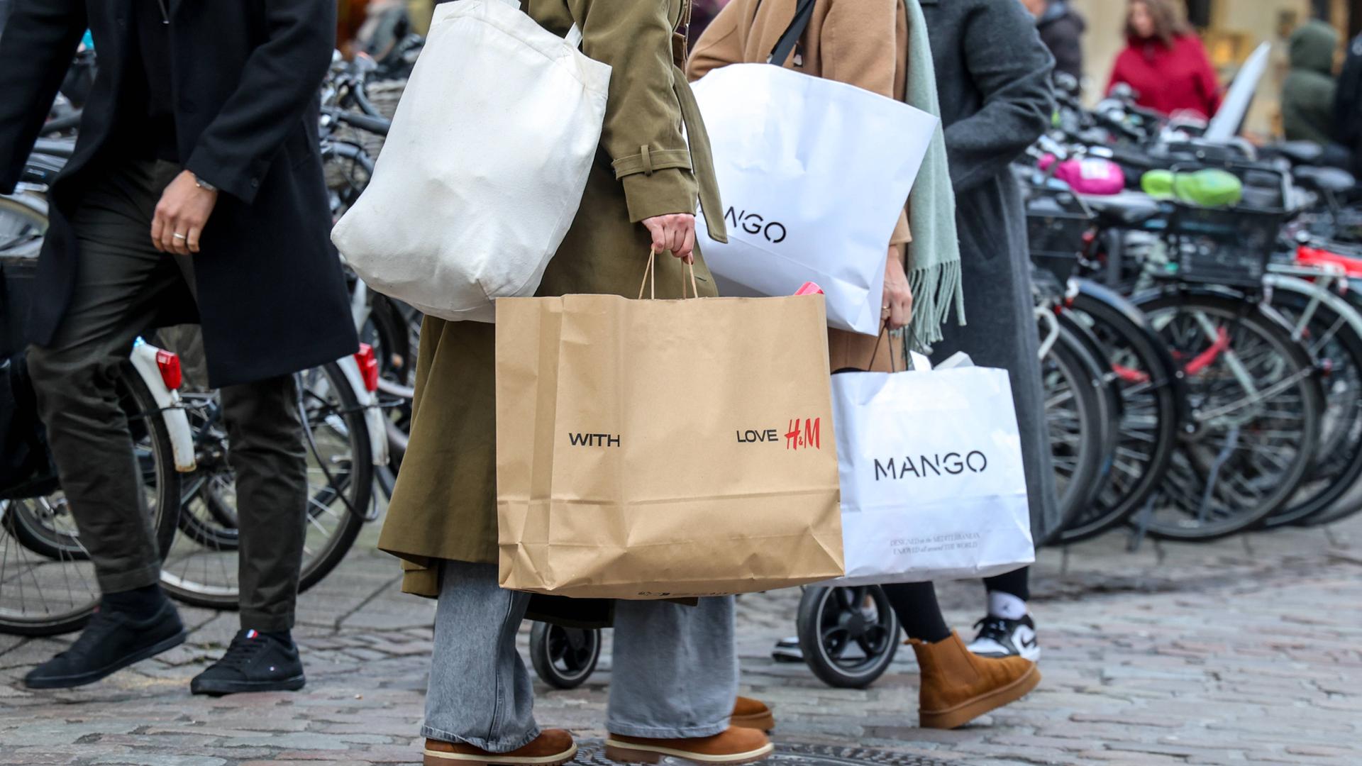 Menschen mit verschiedenen Einkaufstüten in einer Fußgängerzone.