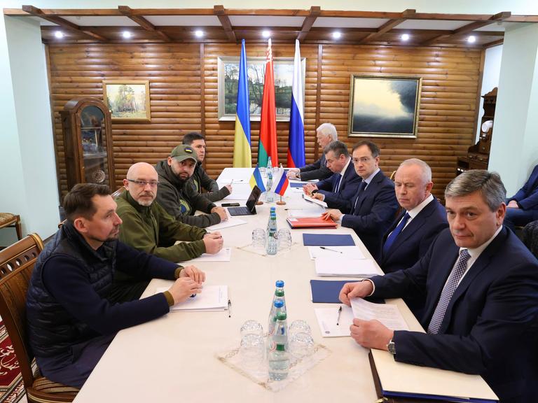 Vertreter der Ukraine (links) und Russlands sitzen an einem Verhandlungstisch in der Nähe der belarussischen Stadt Brest.