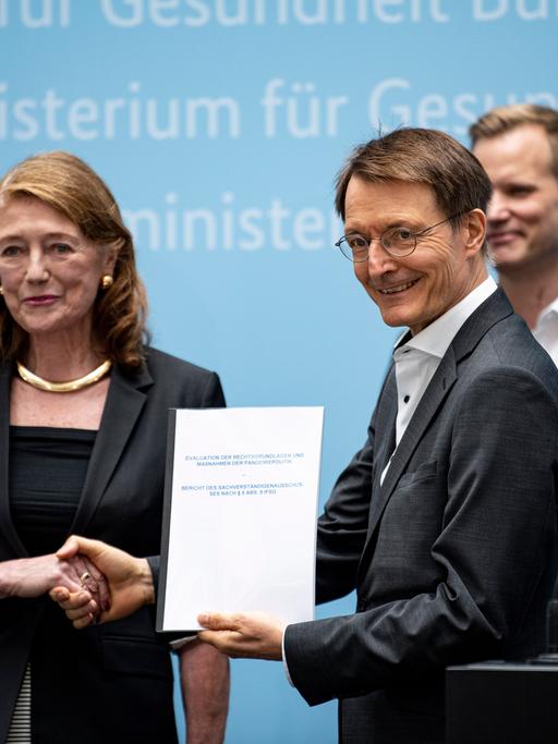 Helga Rübsamen-Schaeff, Virologin, Chemikerin und stellvertretende Vorsitzende des Sachverständigenausschuss zur Evaluation des Infektionsschutzgesetzes (IfSG), übergibt Karl Lauterbach (SPD), Bundesminister für Gesundheit, auf einer Pressekonferenz den Evaluationsbericht des IfSG
