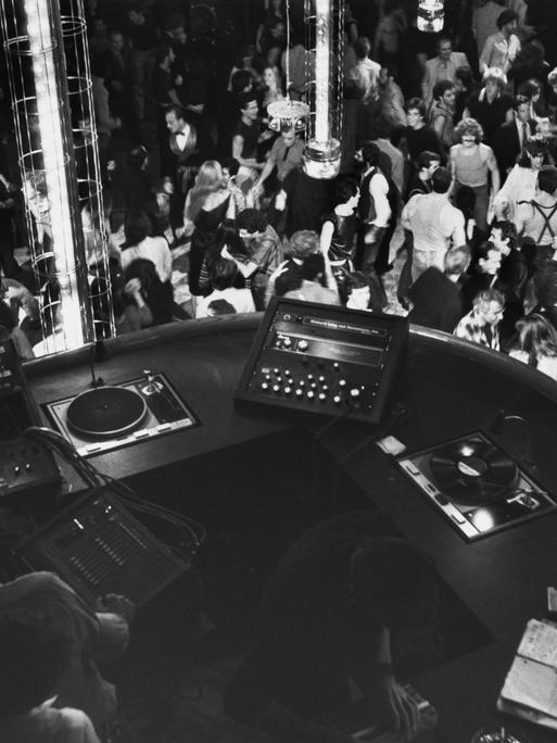 Blick auf einen DJ-Booth von oben, darunter eine große Tanzfläche.
