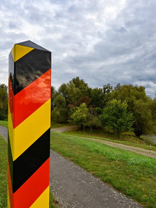 Ein Grenzpfeiler in den Nationalfarben Deutschlands steht auf dem Deich am deutsch-polnischen Grenzfluss Oder in der Ziltendorfer Niederung in Ostbrandenburg