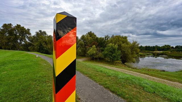 Ein Grenzpfeiler in den Nationalfarben Deutschlands steht auf dem Deich am deutsch-polnischen Grenzfluss Oder in der Ziltendorfer Niederung in Ostbrandenburg