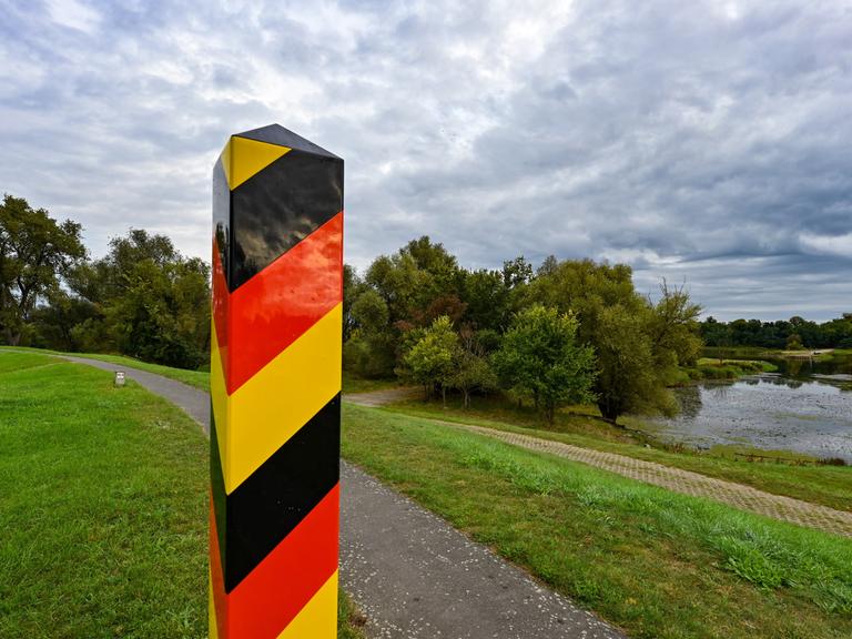 Ein Grenzpfeiler in den Nationalfarben Deutschlands steht auf dem Deich am deutsch-polnischen Grenzfluss Oder in der Ziltendorfer Niederung in Ostbrandenburg