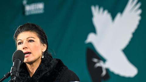 Sahra Wagenknecht spricht zu den Teilnehmern einer Friedensdemonstration vor dem Brandenburger Tor - im Hintergrund ist eine Friedenstaube zu sehen